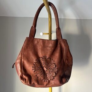 100% Leather brown slouchy top-handle shoulder bag with a mandala cutout design
